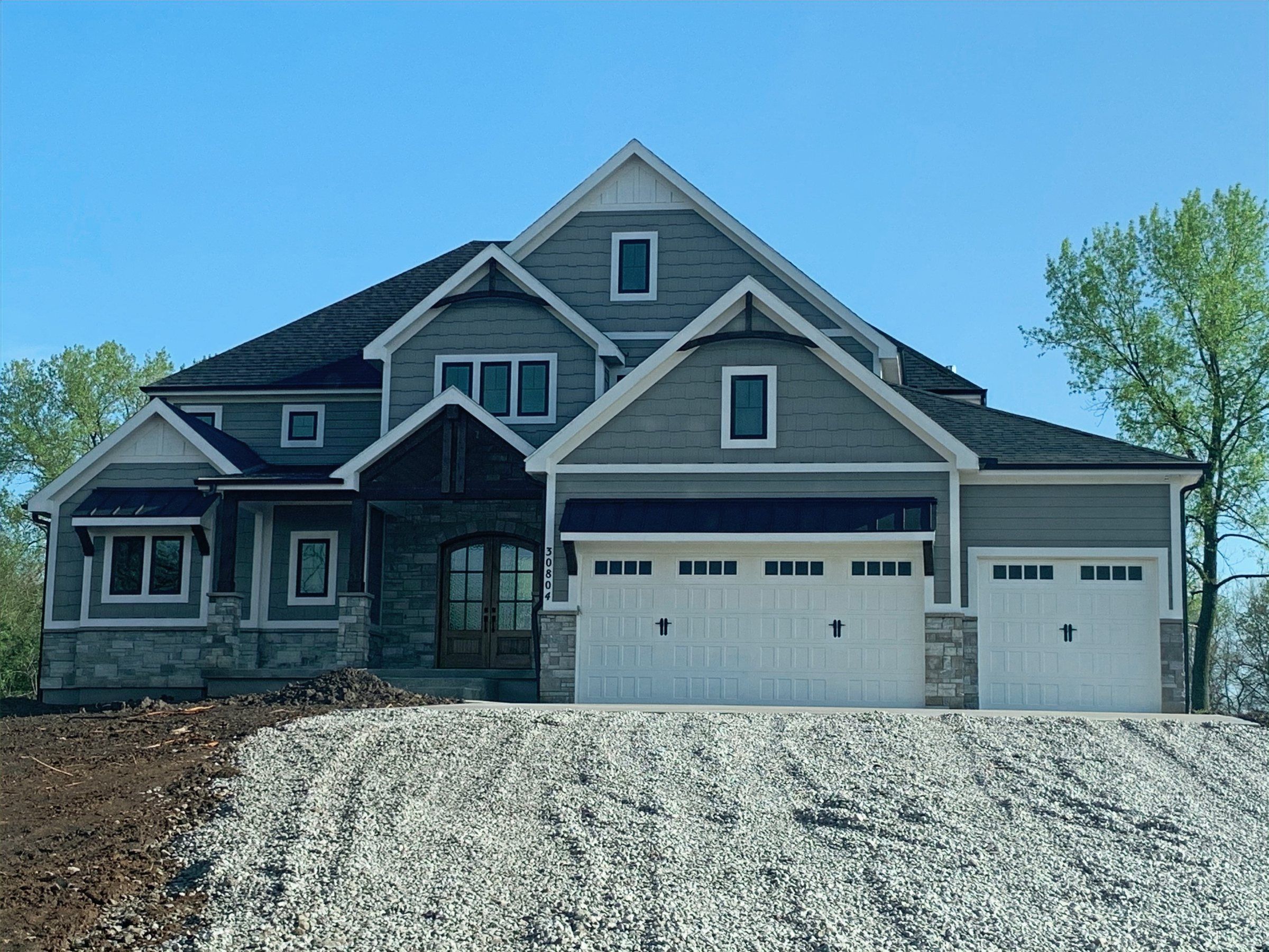 Gray craftsman two-story home with a four-car garage built by JFE Construction on acreage