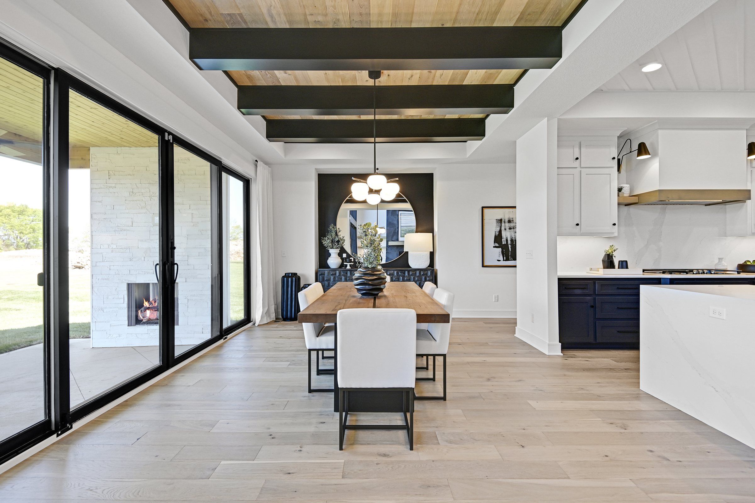 Dining room with a beamed ceiling and a wall of sliding glass doors in a JFE Construction home