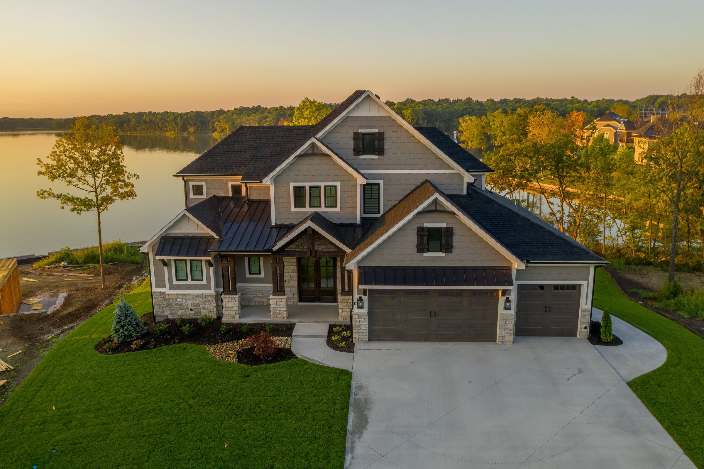 Aerial view at sunrise of a two-story craftsman lake home built by JFE Construction