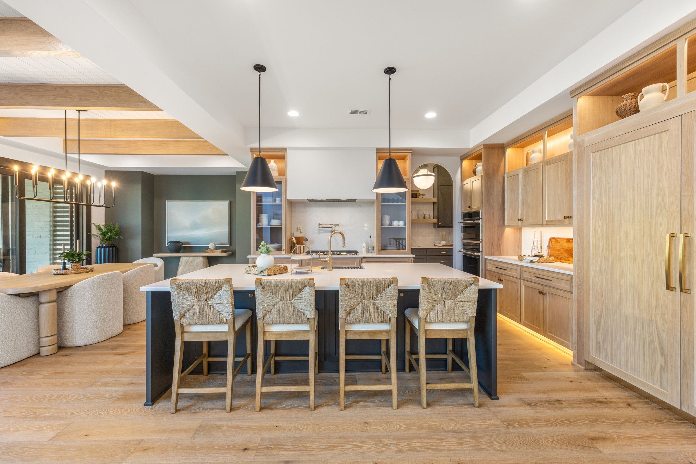 Kitchen with a navy island and light oak cabinetry in the JFE Maplewood IV model, Century Farms
