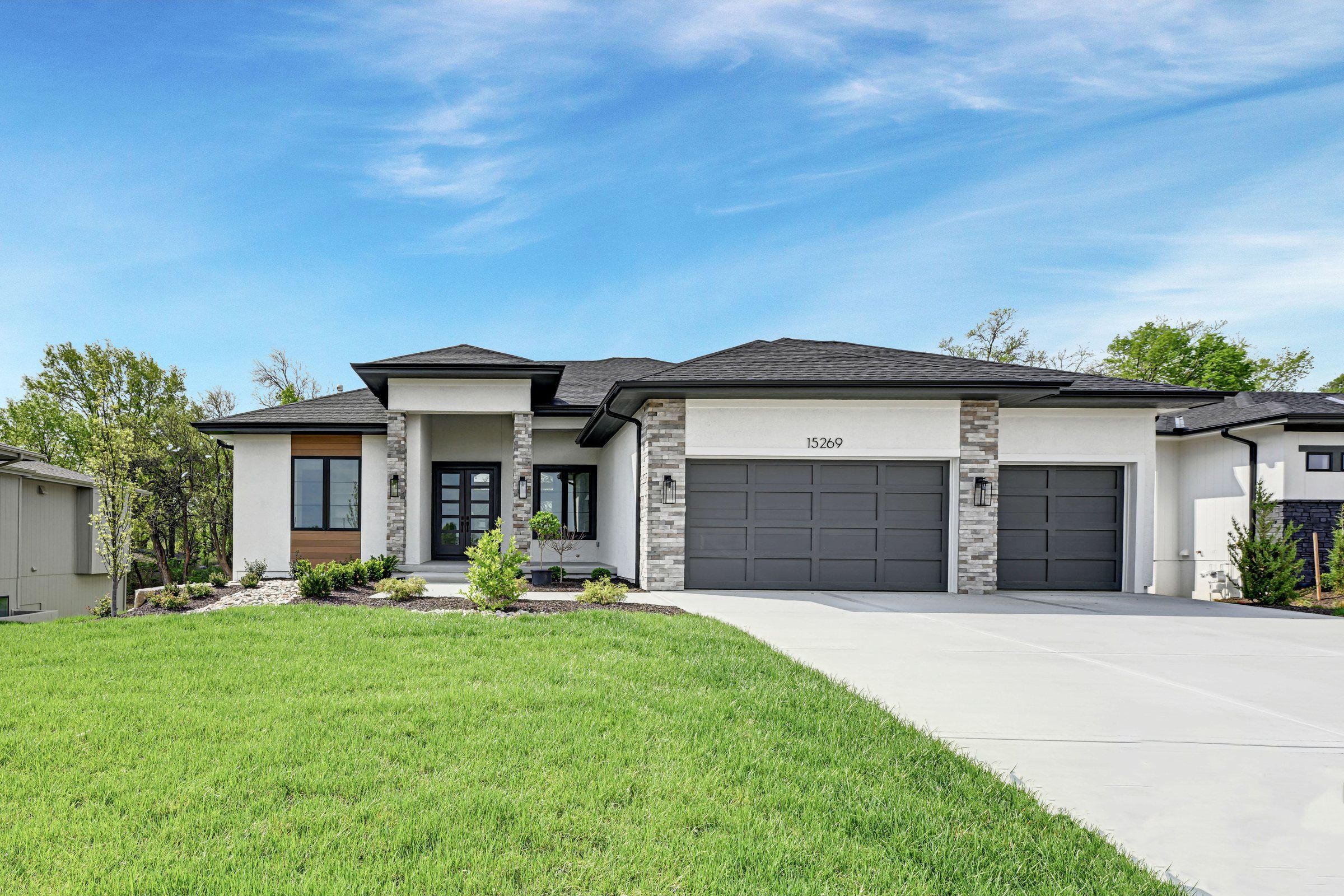 Modern JFE Construction ranch home with a wide driveway in Heritage Ranch, Olathe, Kansas