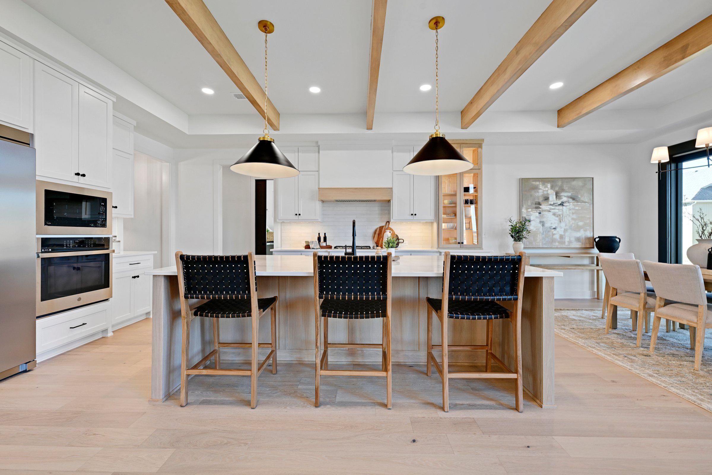 Kitchen with a beamed ceiling and woven stools in the JFE Modern Woodland model, Heritage Ranch