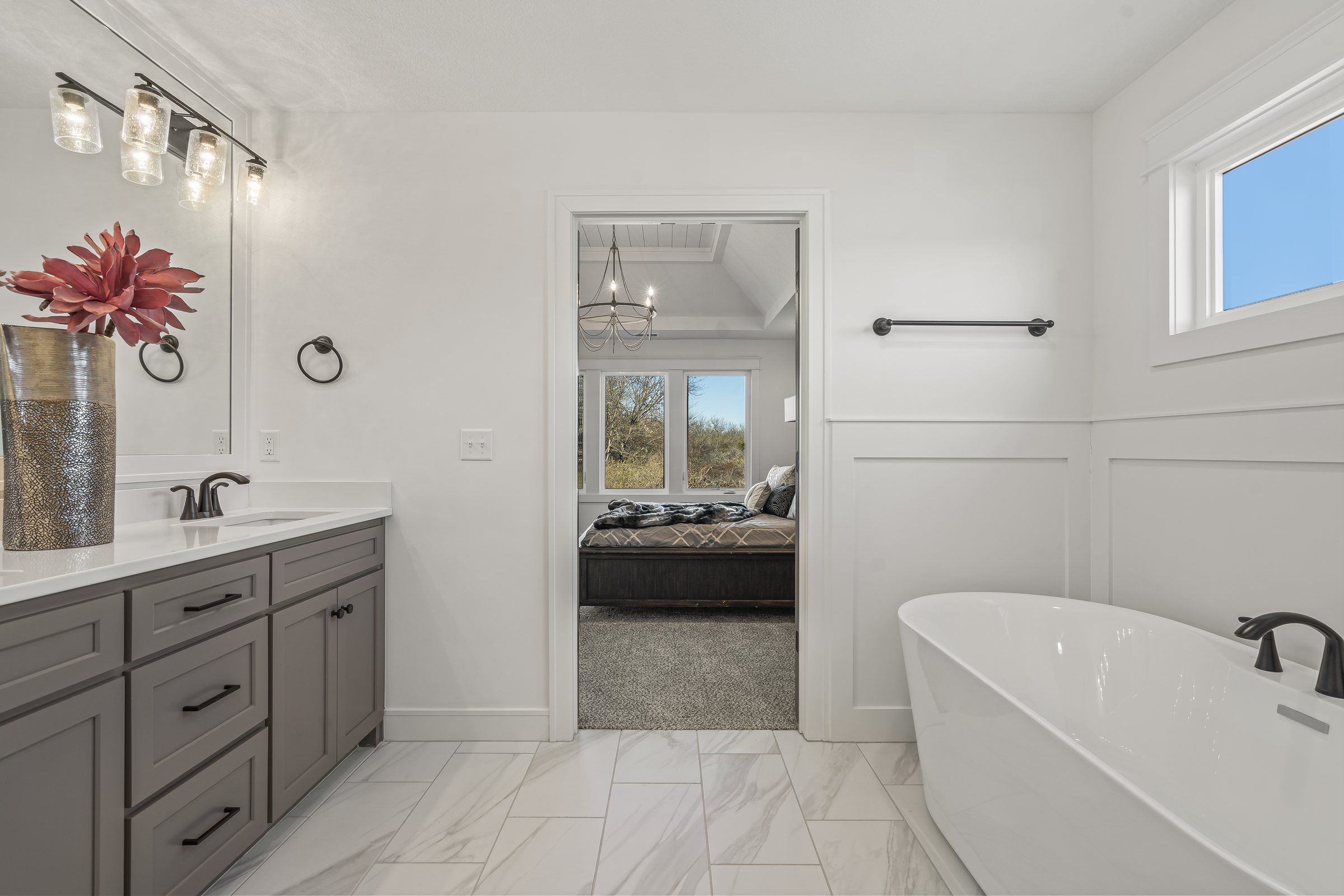 Primary bathroom with a freestanding tub and a double vanity in a JFE Construction home