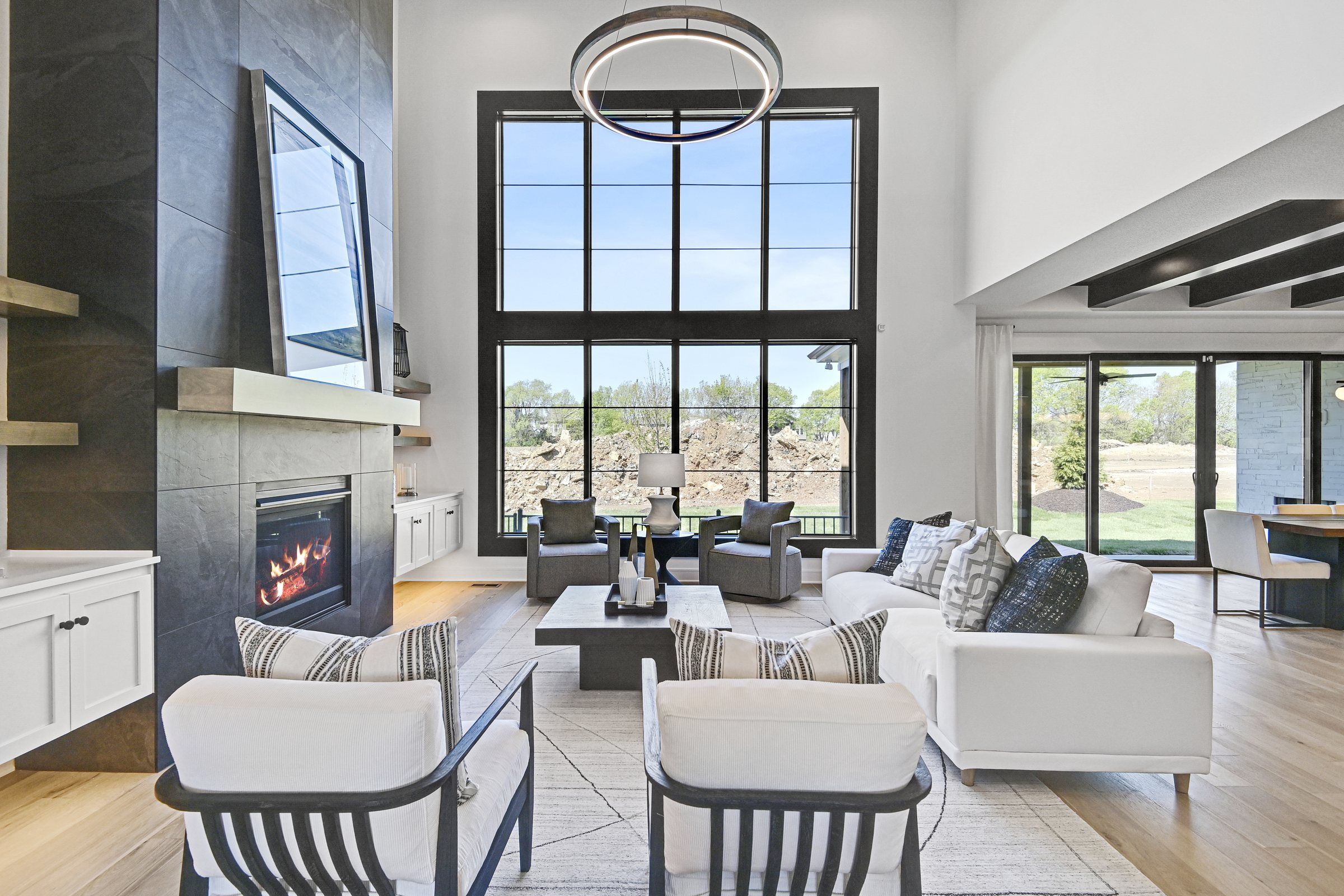 Two-story great room with a window wall and tile fireplace in a JFE Construction home